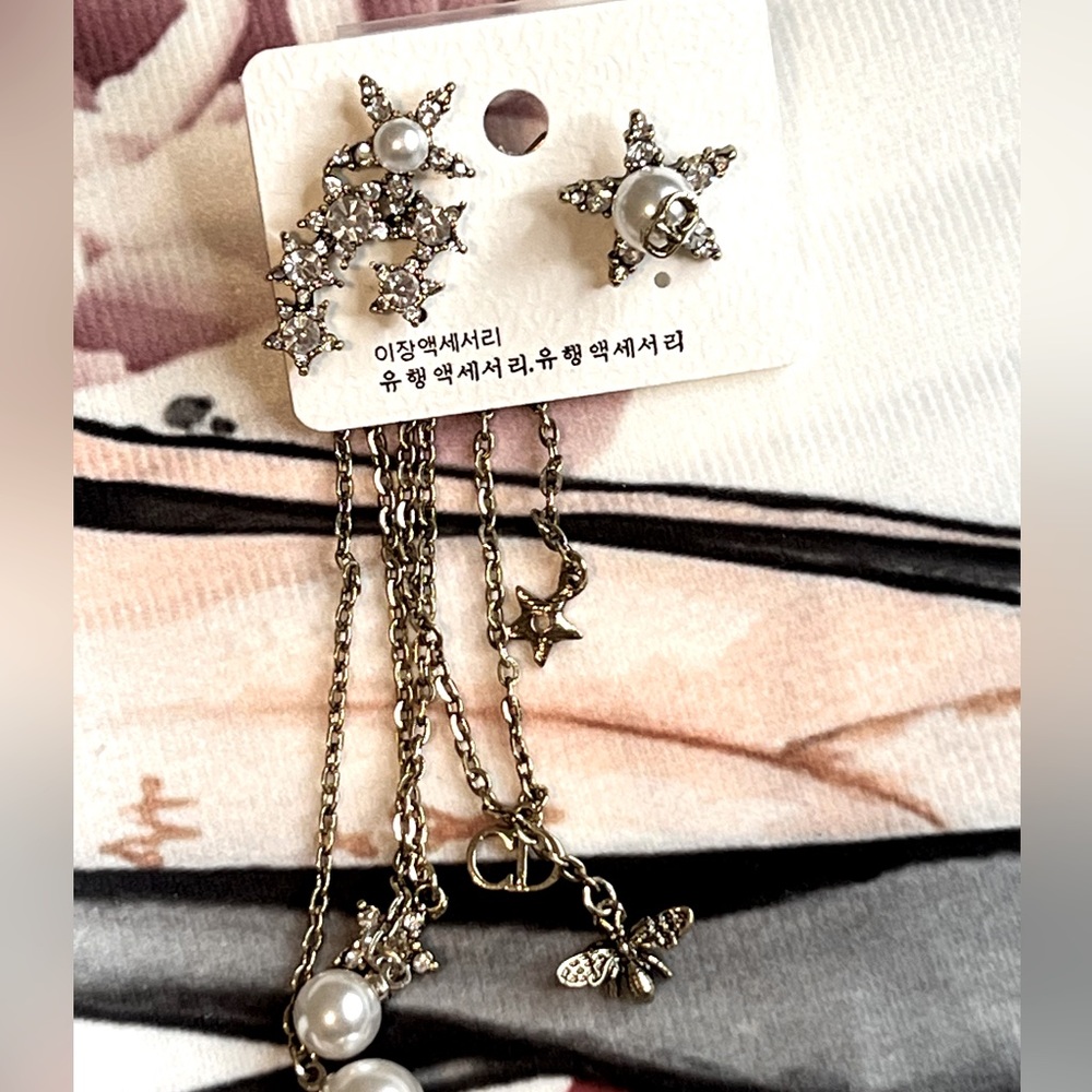 Fashion gold dangling earring adorned with pearls and crystals.
